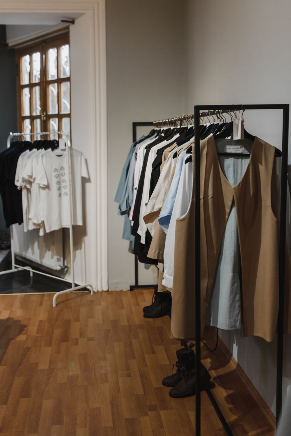 Indoor view of a boutique with stylish clothing racks filled with fashion pieces and apparel.