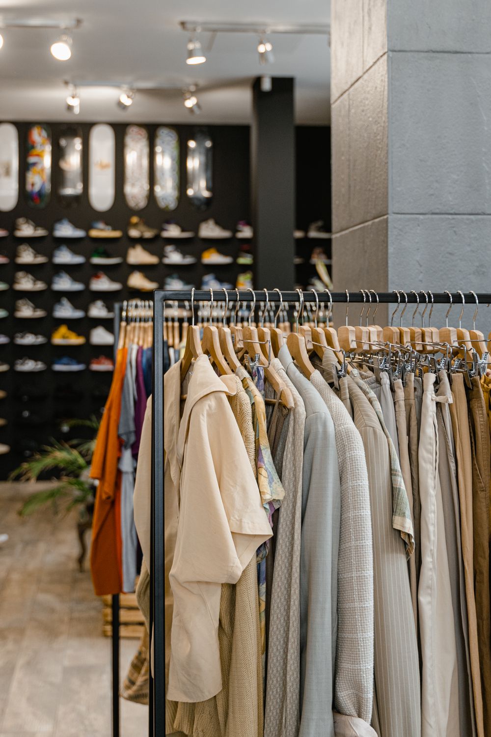 Stylish boutique interior with clothes rack and sneaker wall.